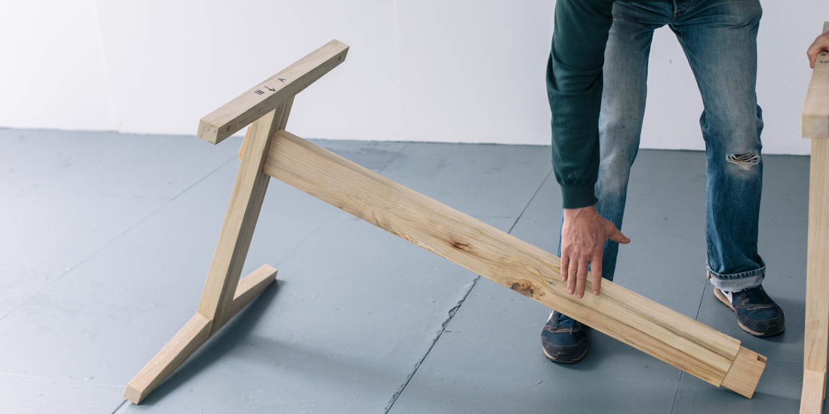 Photo of Simon Cass in the process of assembling the par-avion co. M table.