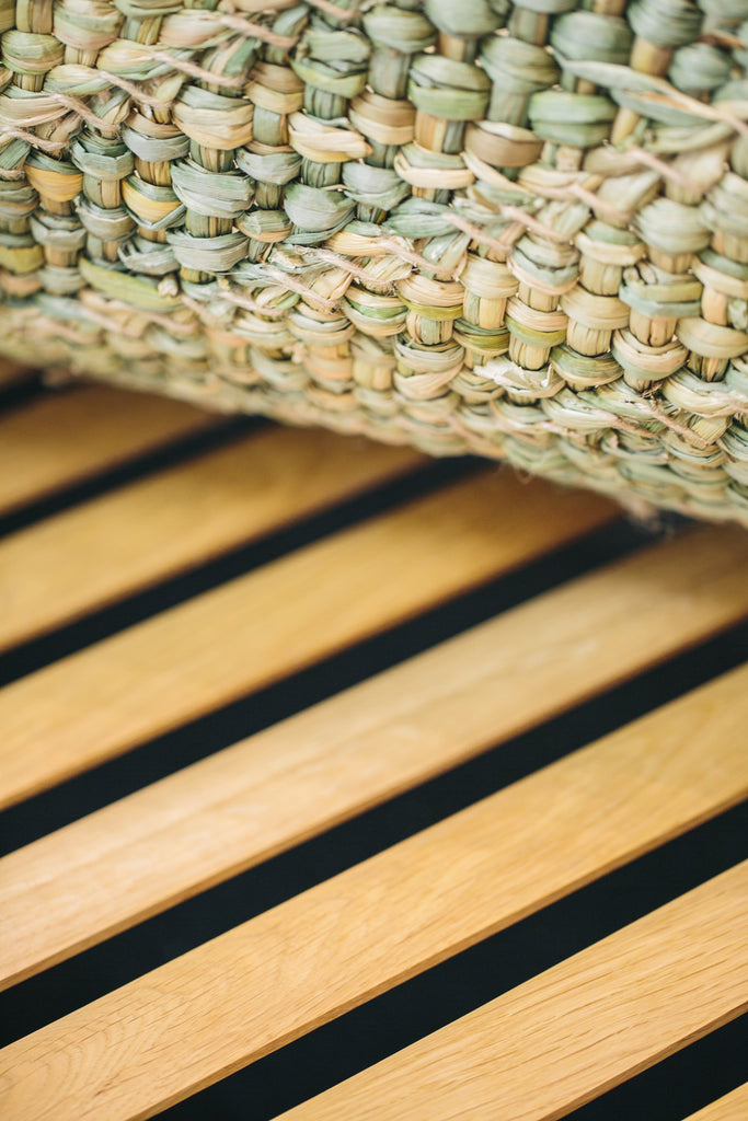 Photo close up of the Lambda Daybed oak slats seat and rush mat.