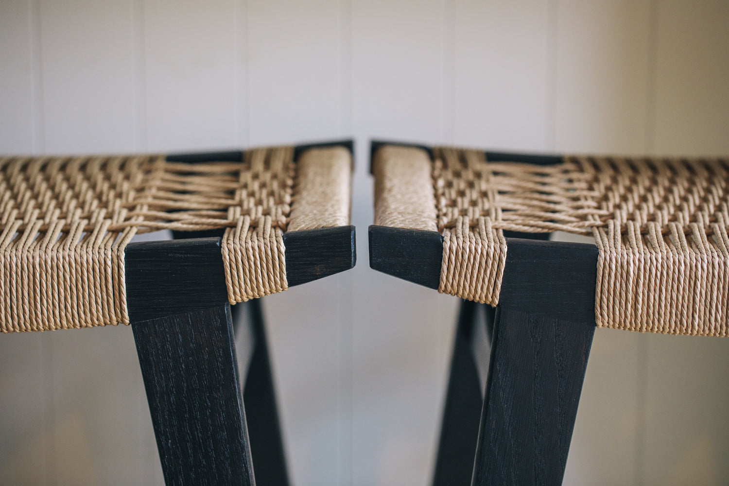 Photo close up of two par-avion co lo-pi bar stools next to each other. Both stools made from ebonised oak and natural Danish Cord.