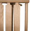 Photo close up of a slatted oak seat on a natural oak pi stool frame on a white background.
