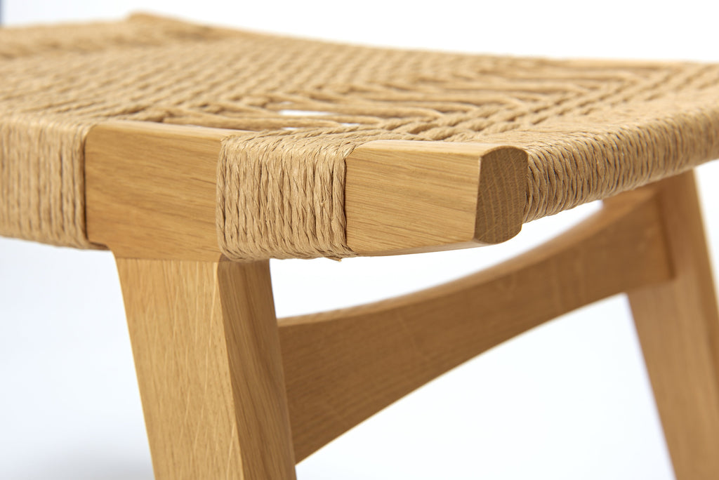 Photo close up of a natural oak and natural Danish Cord pi stool on a white background.